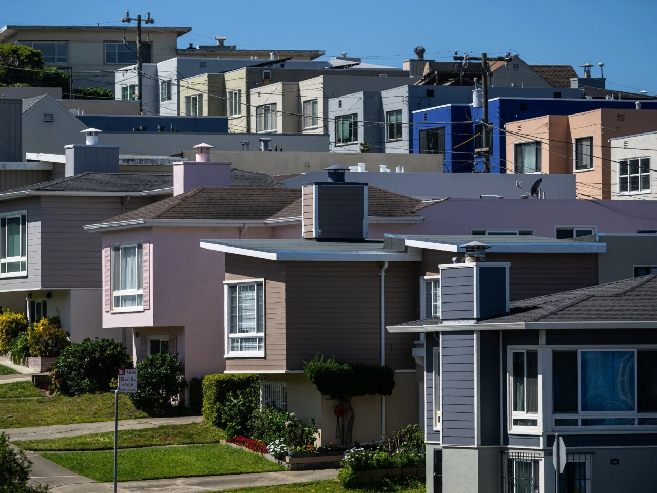 A borrower standing in an apartment lobby holding an envelope and checking their phone for account updates, realistic photo