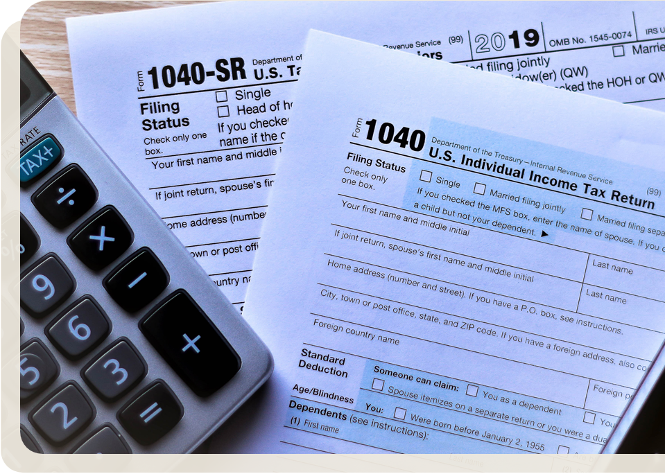 A calculator next to tax forms and a pen on a desk, suggesting retirement tax planning