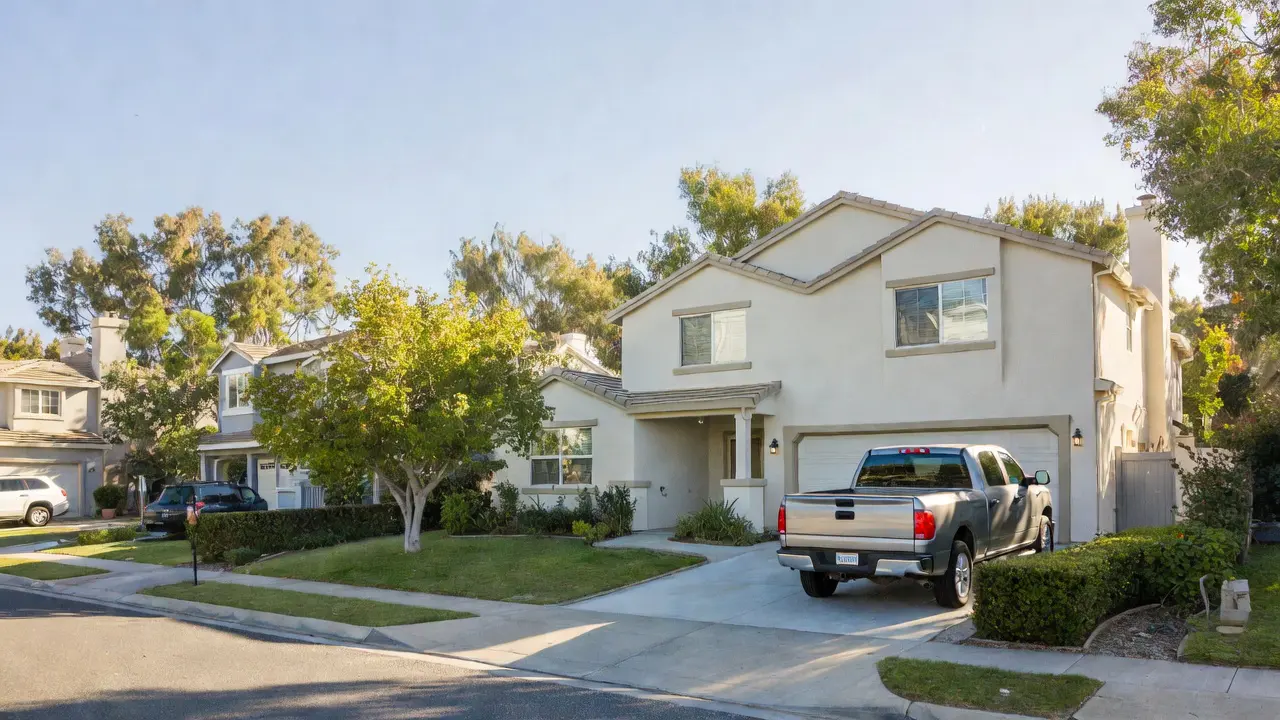 A couple standing in their driveway next to a midsize SUV and a single-family home on a bright day, realistic photography style