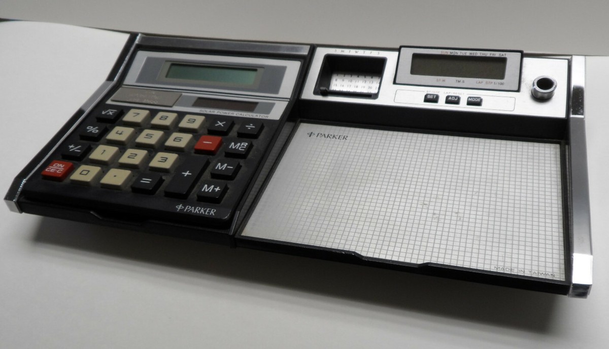 A desk scene with a paper calendar open beside a calculator and a coffee mug, suggesting retirement planning timing