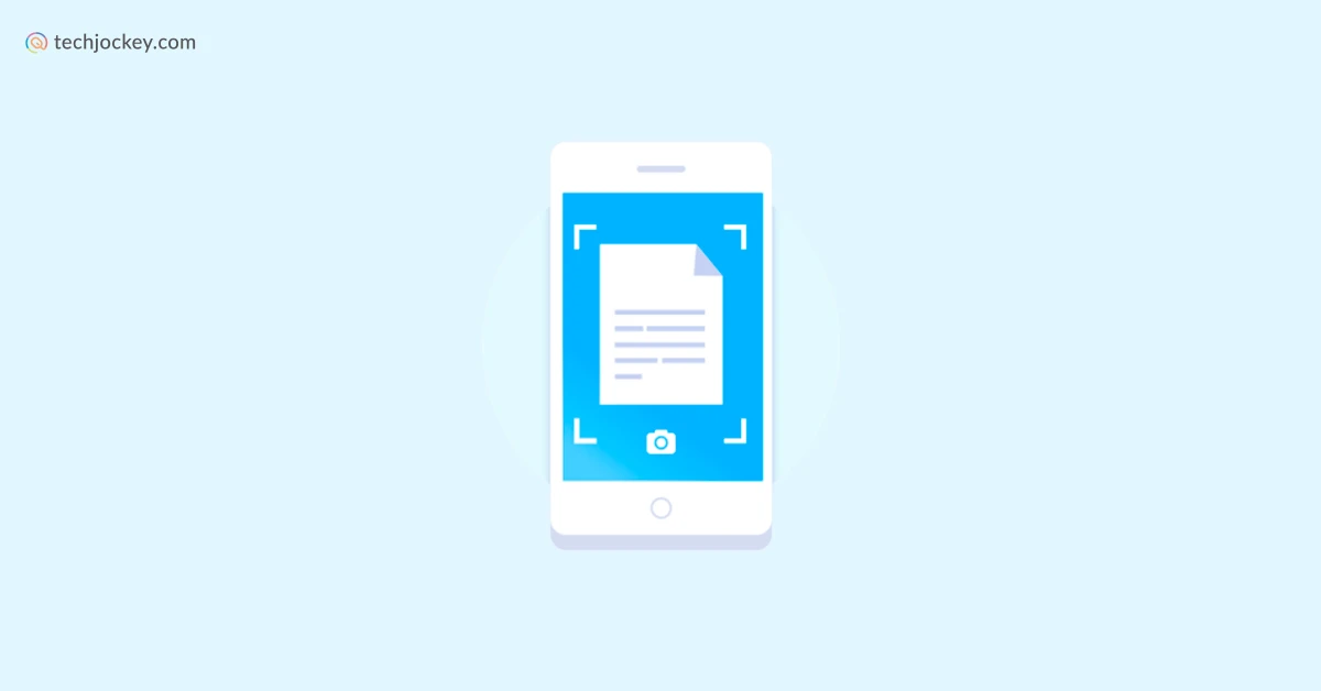 A freelancer holding a smartphone over a paper receipt on a desk while a laptop sits open nearby, close-up photo