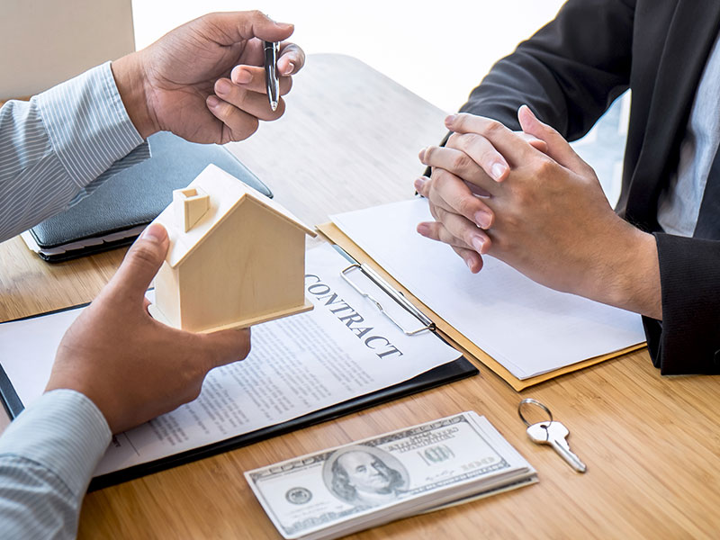 A homeowner reviewing mortgage paperwork with a calculator and house keys on a table, realistic personal finance scene