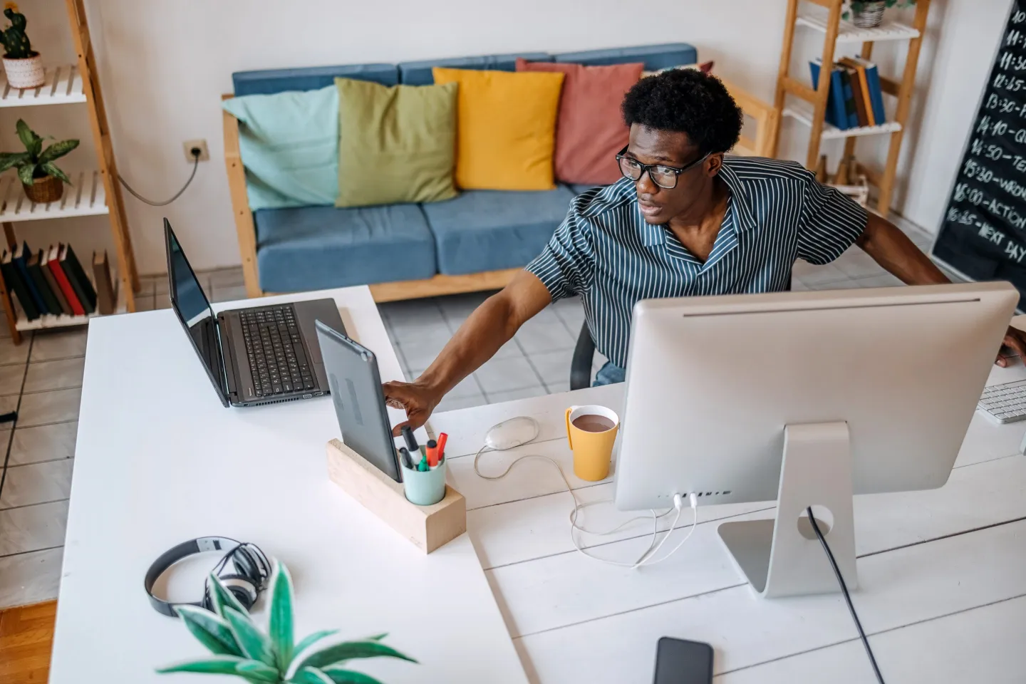 A person in a home office using a laptop to schedule an IRA distribution transfer, realistic photo