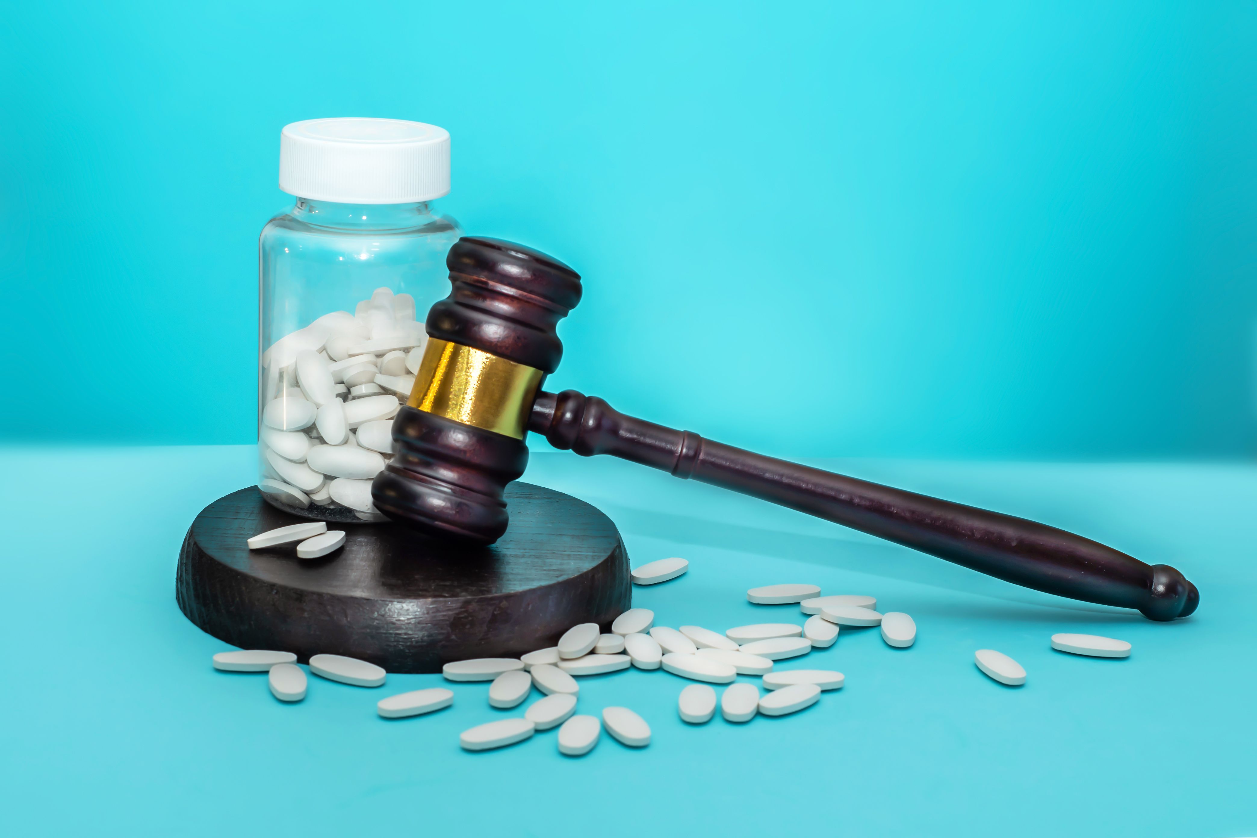 A pharmacist in a small independent pharmacy counting tablets into a prescription bottle on a countertop, real photo