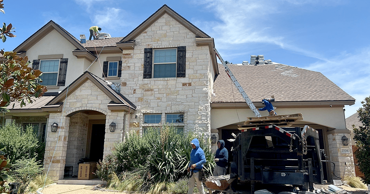 A roofing contractor on a ladder inspecting shingles on a suburban home during a repair visit, realistic outdoor photograph