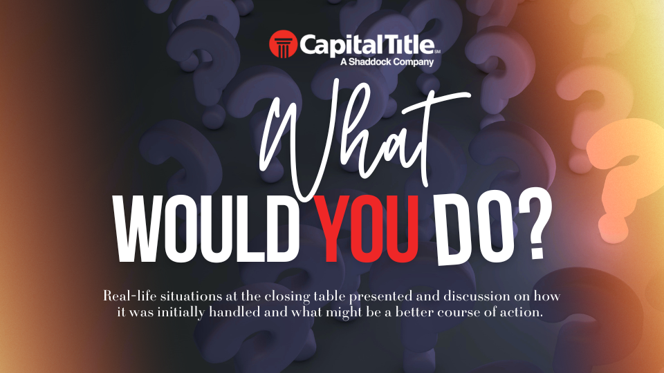 A settlement agent at a title company desk reviewing a stack of closing documents next to a house key, candid office photo style