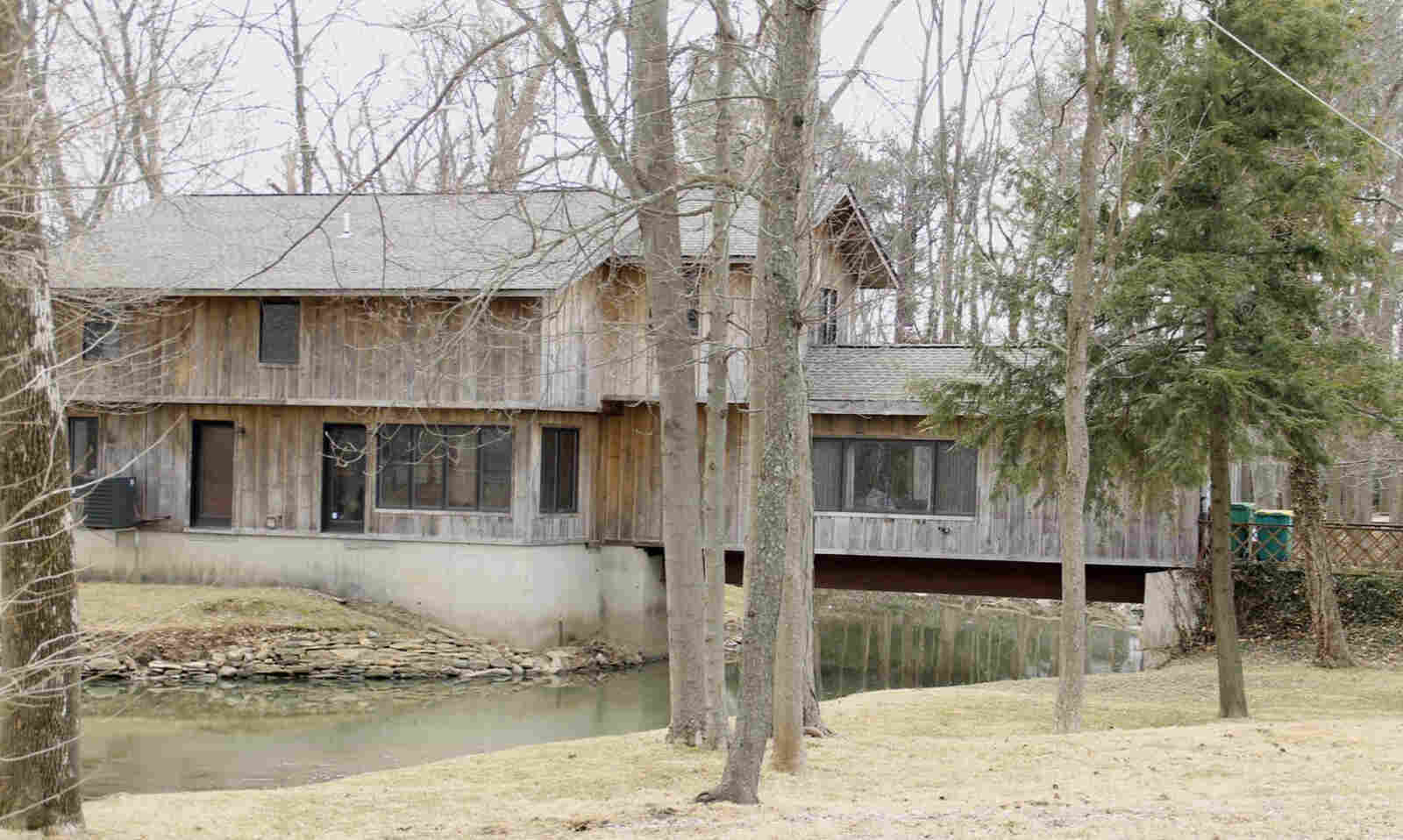 A well-maintained single-family suburban home with a small front porch and spring landscaping in Columbus, Ohio, real photo