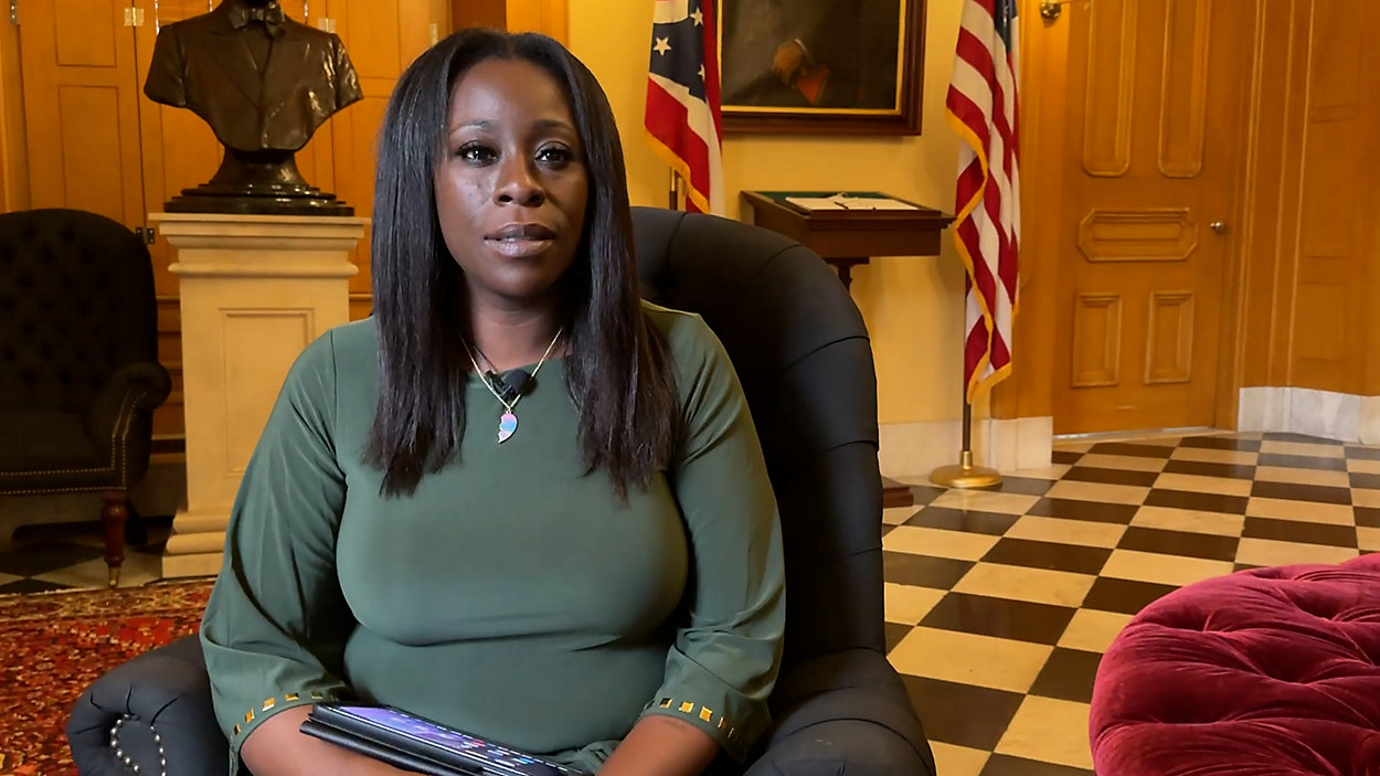 A working parent in Columbus, Ohio walking a small child into a daycare building on a weekday morning, real life photography style