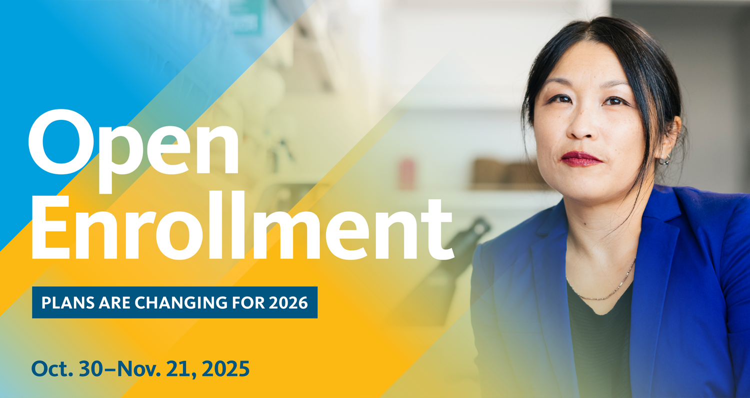 An employee reviewing health benefits paperwork with a laptop open at a desk during an open enrollment meeting in a modern office, real-life photo